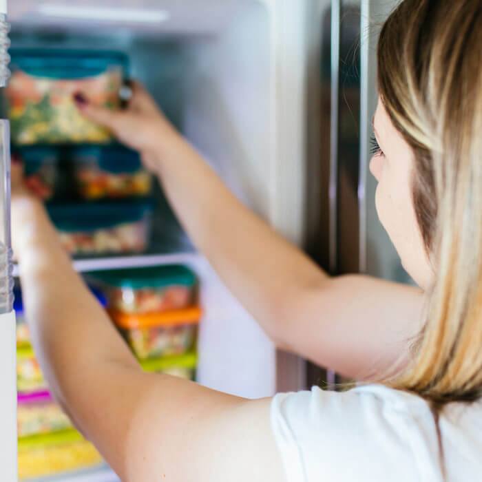 Woman reaching into fridge