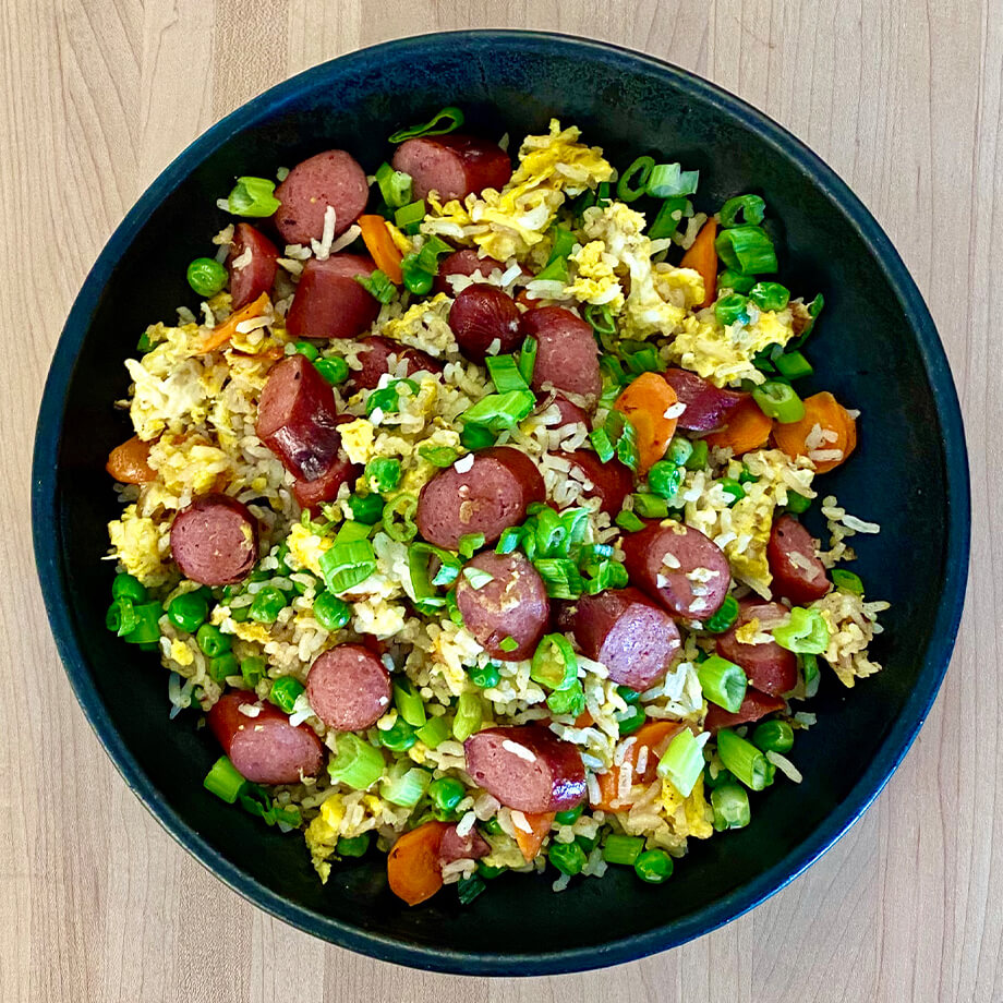 hot dog fried rice in a black bowl