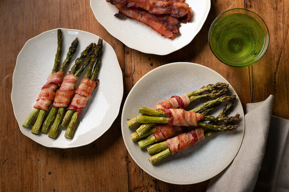 Oven Roasted Bacon Wrapped Asparagus on white serving plates