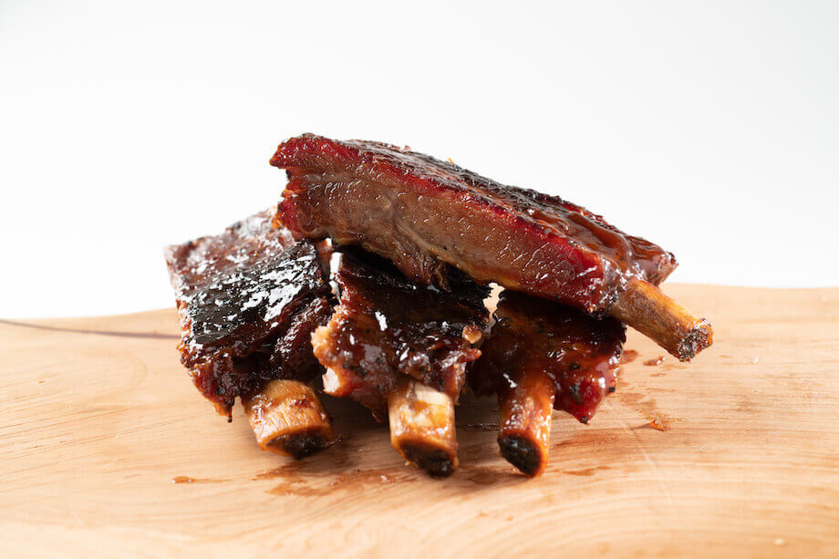 Ribs with sauce sitting on a wooden board
