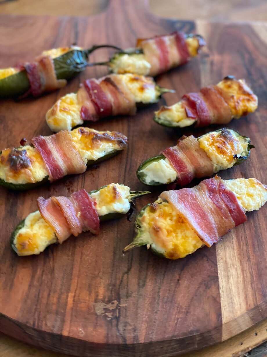 Bacon wrapped jalapeno poppers displayed on a wooden board
