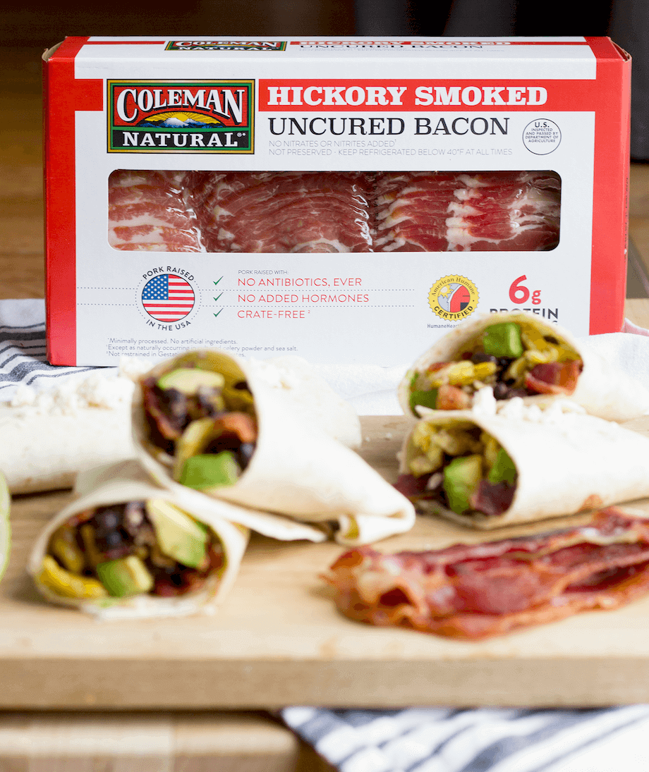 Box of hickory smoked bacon behind tortilla wraps with bacon and vegetables