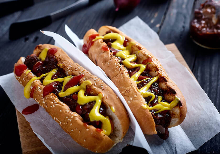 Two new york hot dogs topped with ketchup and mustard