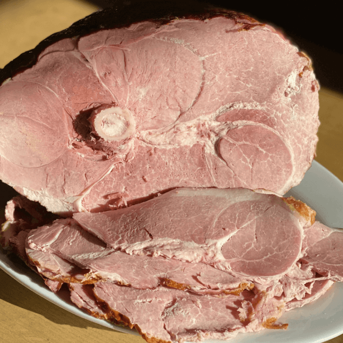 A sliced whole ham on a plate