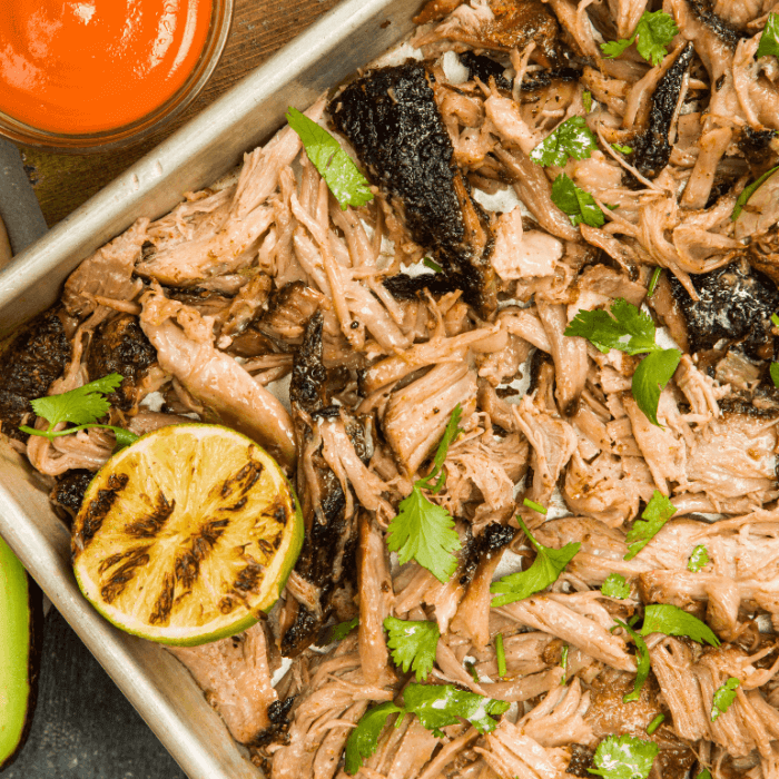 Pulled pork in a pan with lime and seasoning